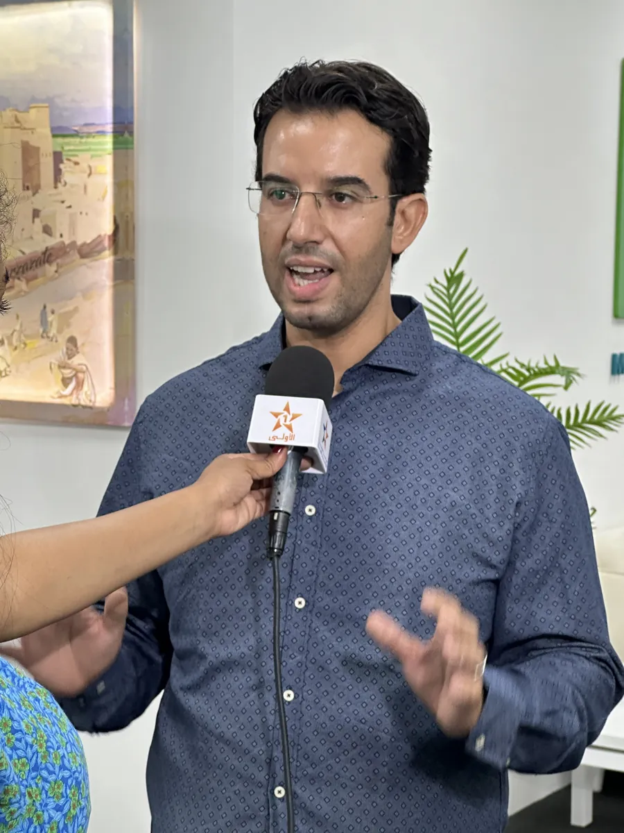 Dr CHARRASS Abdelmajid répondant à une interview télévisée, micro tendu