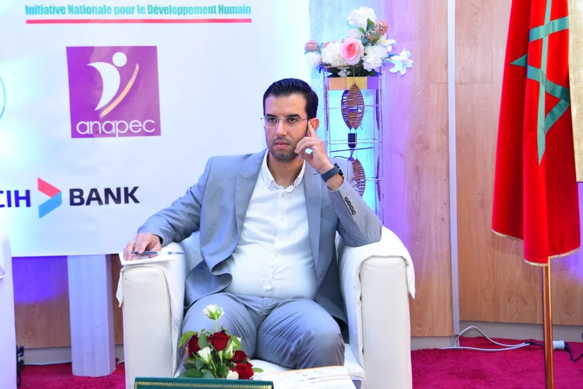 Dr CHARRASS Abdelmajid en costume clair dans un fauteuil lors d’une table ronde.